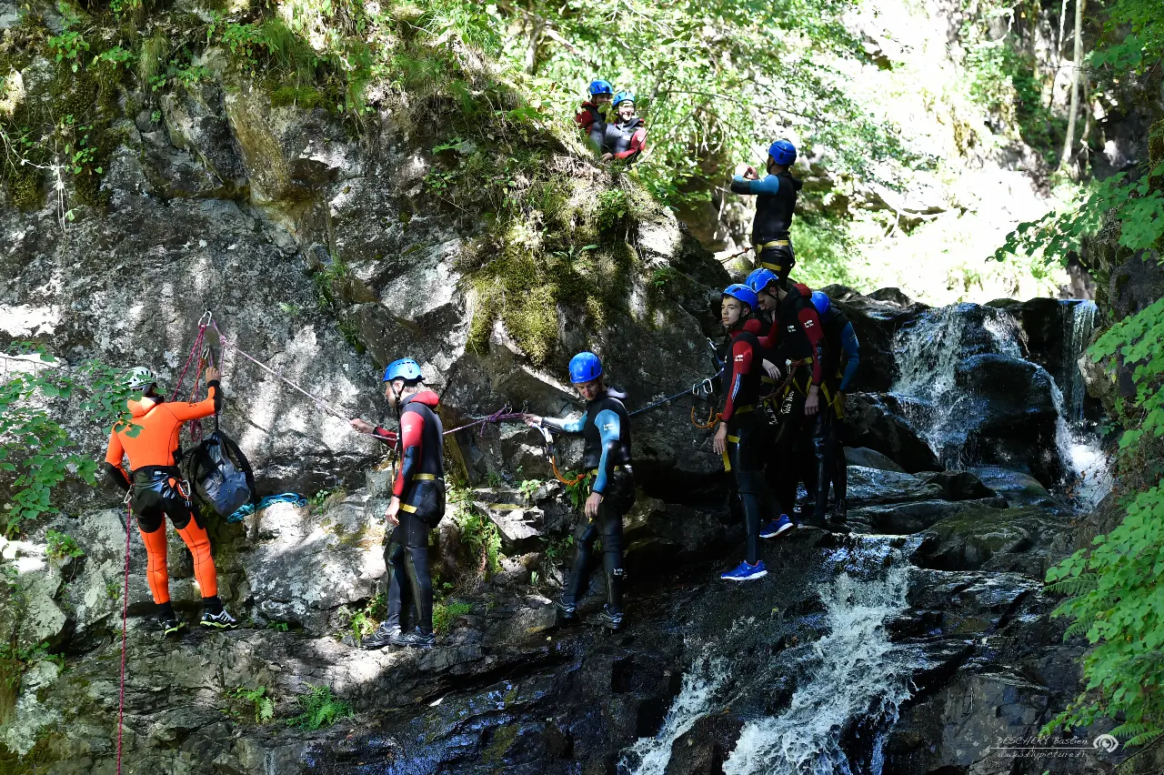 Canyoning_Groupe_Jeunes_sur paroi_Main courante_guide devant_Auvergne Loisirs